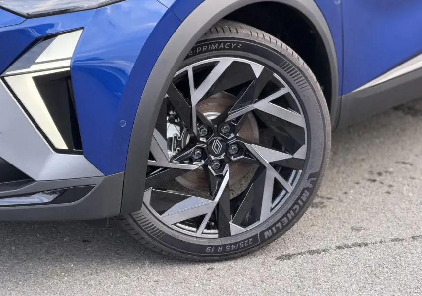 Gros plan sur la roue avant droite du Renault Captur Bleu Iron, jante aluminium 19 pouces Elixir au design géométrique.
