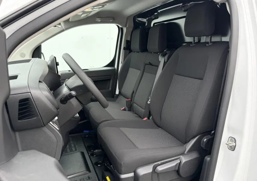 Vue intérieure côté conducteur du Peugeot Expert Fourgon blanc Icy, montrant la banquette 3 places en tissu bi-ton noir et gris.