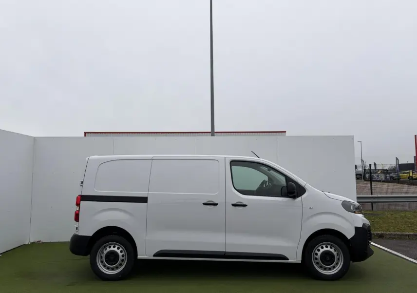 Vue de profil côté gauche d'un Peugeot Expert Fourgon blanc Icy avec jantes tôle 17 pouces et bande noire latérale.