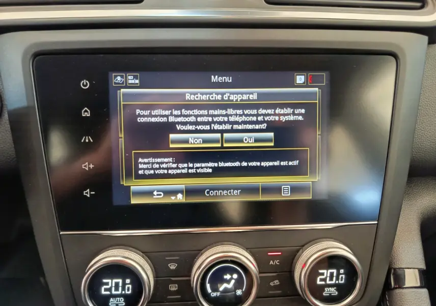 Gros plan sur l’écran tactile central et la commande de climatisation du Renault Kadjar Business Blue dCi 115 EDC 2022 gris foncé.