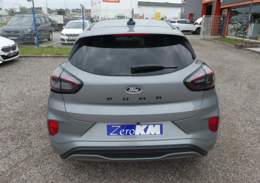 Vue arrière d'un Ford Puma gris métallisé 2025 avec vitres arrière surteintées et logo Ford bien visible.