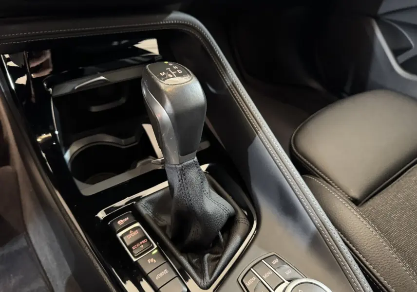 Gros plan sur la commande de boîte automatique et les modes de conduite du BMW X2 xDrive25e M Sport, intérieur noir.
