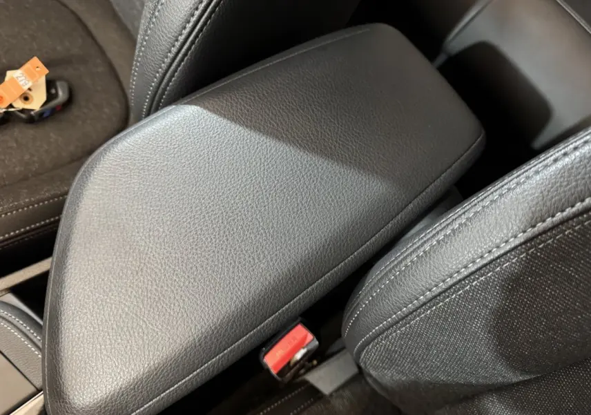 Gros plan sur l'accoudoir central en cuir noir de l'intérieur du BMW X2 xDrive25e M Sport BVA6 2021.