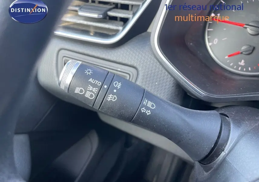 Gros plan sur la commande des phares et clignotants dans l'habitacle d'une Renault Clio Société blanche.