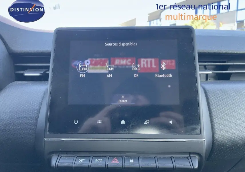 Écran tactile central affichant les sources audio dans l'habitacle d'une Renault Clio Société blanche.