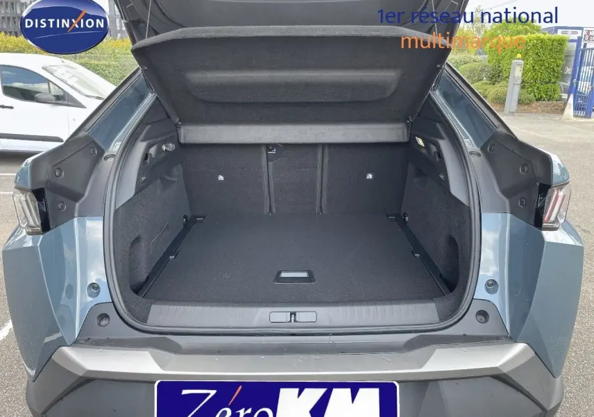 Coffre ouvert vu de l'arrière d'un Peugeot 3008 Hybrid bleu Ingaro Metal avec intérieur noir et hayon relevé.