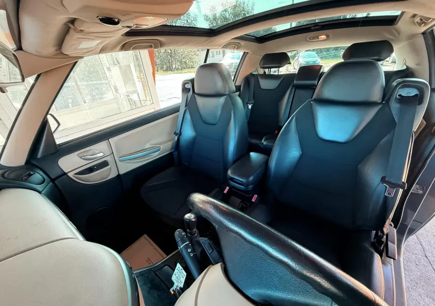 Intérieur du Renault Avantime gris, vue avant montrant sièges noirs en cuir et toit ouvrant panoramique.