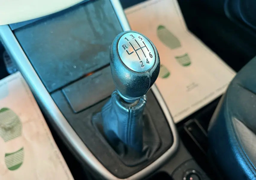 Le levier de vitesses manuel noir en gros plan dans l'habitacle d'une Renault Avantime gris, avec tapis beige visible.