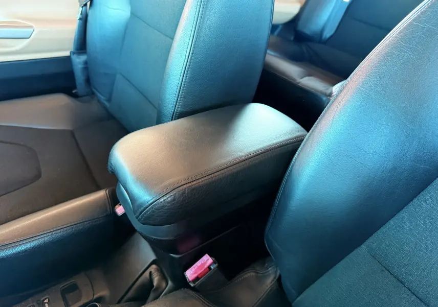 Accoudoir central en cuir noir entre les sièges avant d'une Renault Avantime gris, vue intérieure rapprochée.