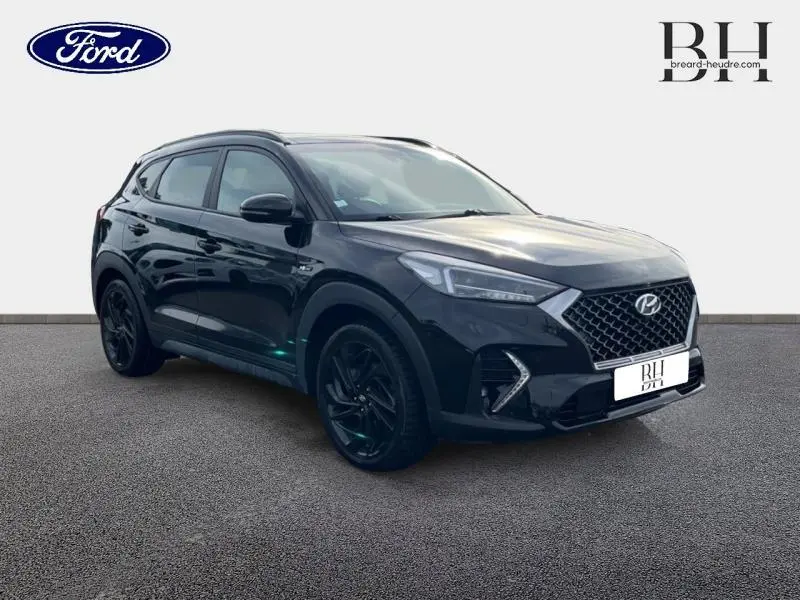 Hyundai Tucson Phantom Black Métal en 3/4 avant droit, avec calandre chromée et jantes noires élégantes.