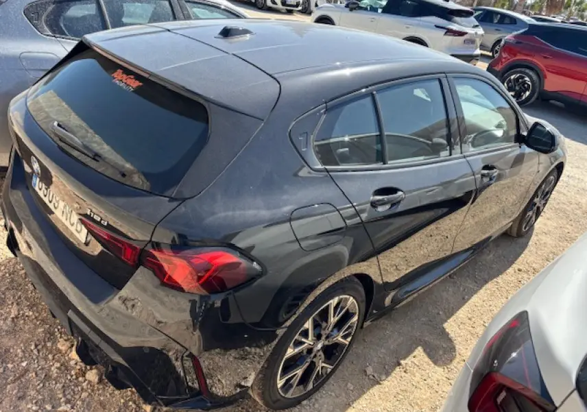 BMW Série 1 118d noir métal vue 3/4 arrière droit, jantes alliage 18 pouces et feux arrière LED visibles