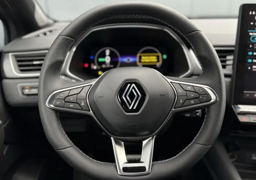 Vue frontale du volant noir avec surpiqûres tricolores du Renault Captur Esprit Alpine 2025, tableau de bord numérique en arrière-plan.