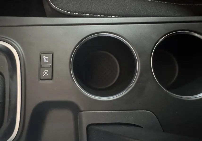 Gros plan sur la console centrale noire avec porte-gobelets et commandes du régulateur de vitesse de la Renault Mégane Business.
