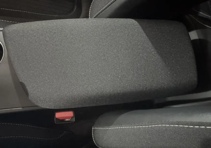 Gros plan sur l'accoudoir central noir et tissu gris foncé avec surpiqûres blanches dans une Renault Mégane Business 2019.