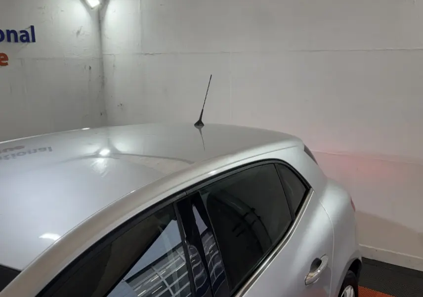 Vue 3/4 arrière droite d'une Renault Mégane Business gris clair avec antenne de toit et vitres teintées.