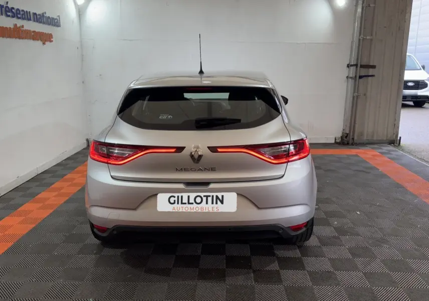 Vue arrière d'une Renault Mégane gris clair avec feux arrière LED allumés dans un garage.