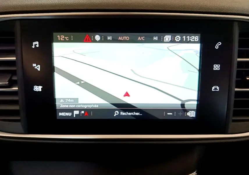 Écran tactile central du tableau de bord de la Peugeot 308 blanc, affichant la navigation GPS en mode carte.