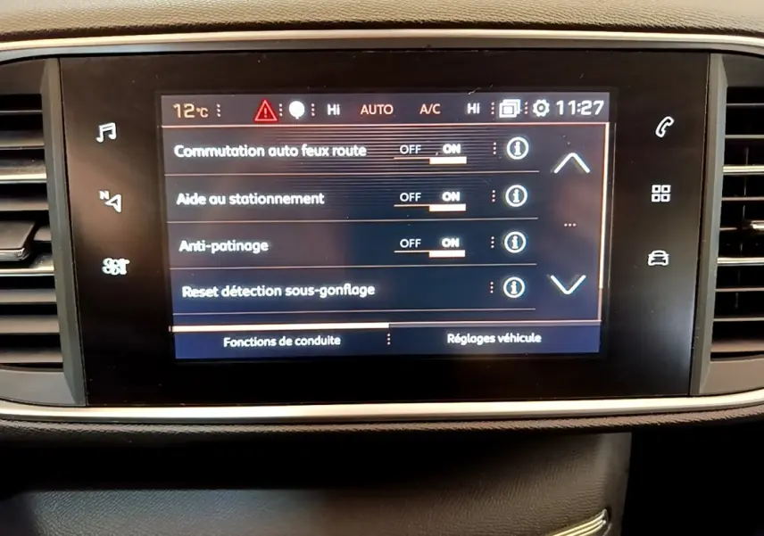 Écran tactile central affichant les réglages d’aide à la conduite dans l’habitacle d’une Peugeot 308 blanche.