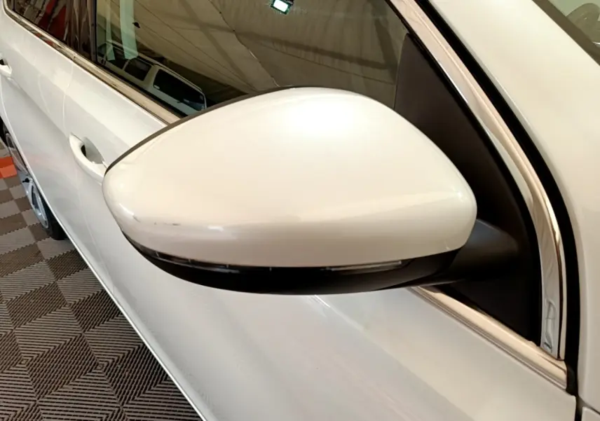 Rétroviseur côté conducteur blanc de Peugeot 308 2017, vue rapprochée sur la portière et la vitre.