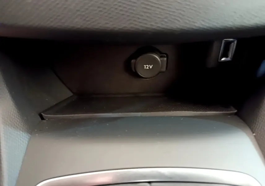Prise 12V et port USB dans la console centrale d'une Peugeot 308 blanche, vue intérieure rapprochée.