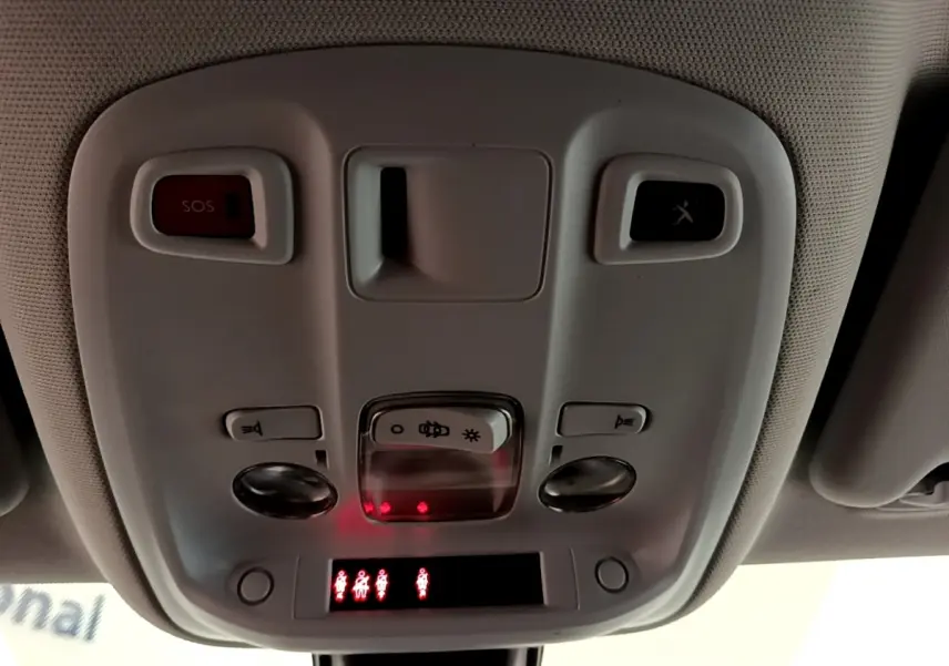 Vue en gros plan du plafonnier intérieur gris avec boutons SOS et éclairage de la Peugeot 308 blanche de 2017.