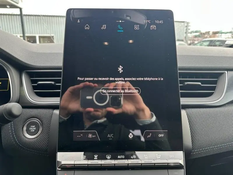 Écran tactile central du tableau de bord du Renault Captur 2026, avec commandes climatisation et bouton Start/Stop visible.