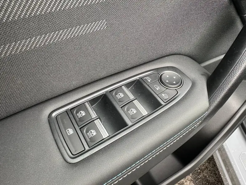 Gros plan sur les commandes des vitres et rétroviseurs côté conducteur du Renault Captur 1.8 E-Tech gris Rafale/Noir Étoilé 2026.