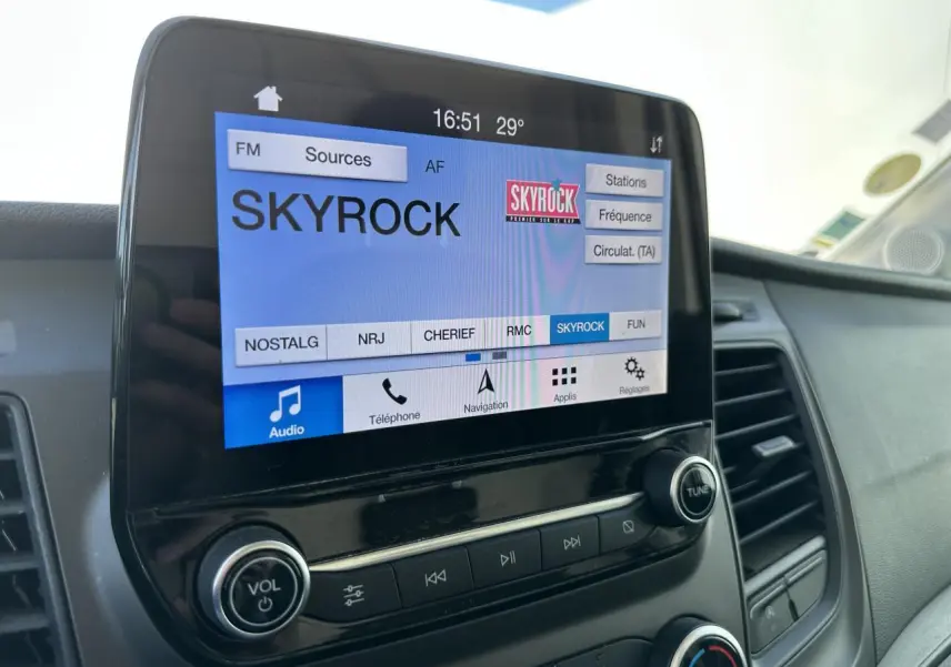 Écran tactile du système audio SYNC 3 du Ford Transit Fourgon blanc, affichant la radio Skyrock.