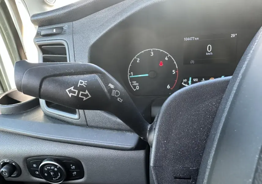 Gros plan sur la manette de clignotants et le tableau de bord numérique du Ford Transit Fourgon blanc de 2020.