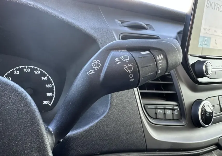 Gros plan sur la commande d'essuie-glace du tableau de bord noir du Ford Transit Fourgon blanc, version 2020.