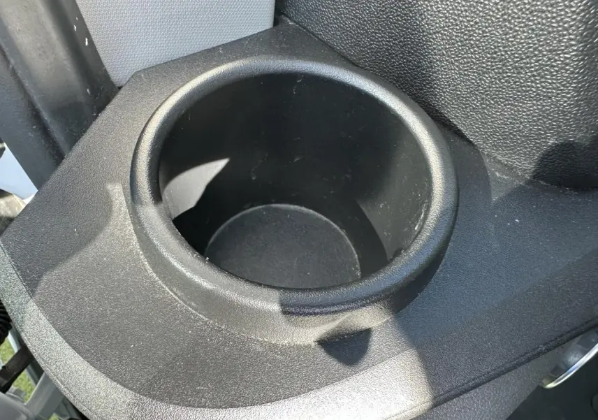 Gros plan sur le porte-gobelet noir dans l'habitacle du Ford Transit Fourgon blanc, version Trend Business 2020.