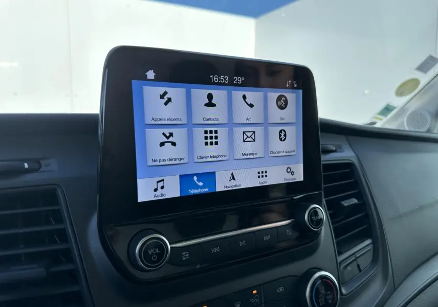 Écran tactile central du système SYNC 3 du Ford Transit Fourgon blanc, vue rapprochée du tableau de bord côté passager.