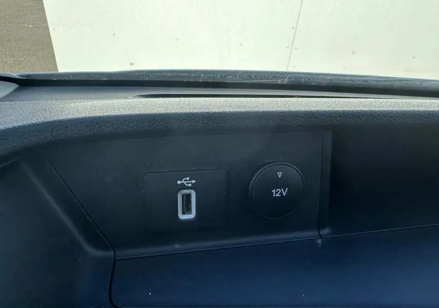 Gros plan sur la prise USB et la sortie 12V du tableau de bord noir du Ford Transit Fourgon blanc de 2020.