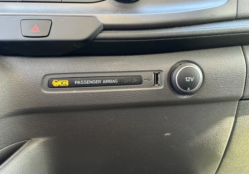 Gros plan sur le tableau de bord noir du Ford Transit Fourgon 2020 montrant témoin airbag passager activé et prise 12V.