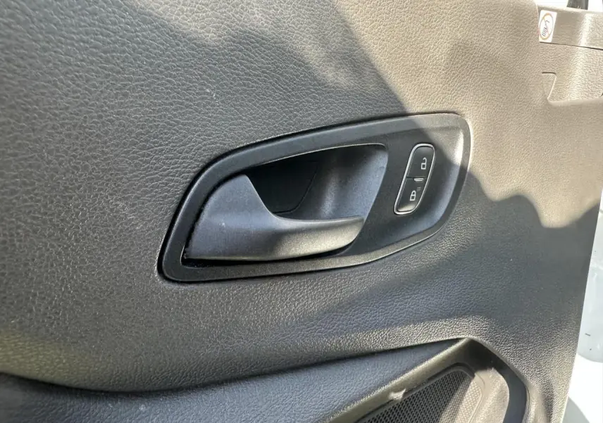 Poignée intérieure de porte côté gauche en plastique noir du Ford Transit Fourgon blanc 2020, avec boutons de verrouillage.