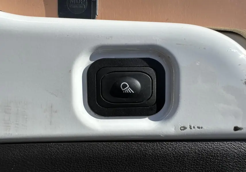 Gros plan sur l'interrupteur d'éclairage renforcé à LED du compartiment de chargement du Ford Transit Fourgon blanc.