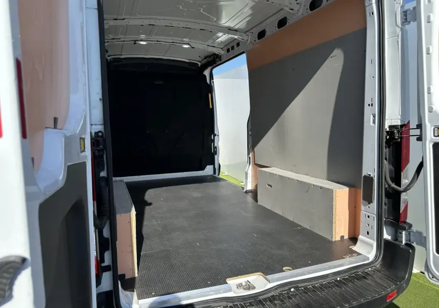 Vue intérieure arrière du fourgon blanc Ford Transit IV 2.0 EcoBlue 2020 avec espace de chargement vide et plancher noir.