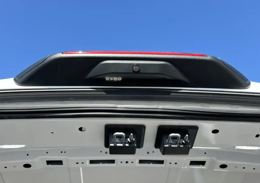 Gros plan sur l'intérieur de la porte arrière blanche du Ford Transit Fourgon, montrant la caméra de recul et les fixations.