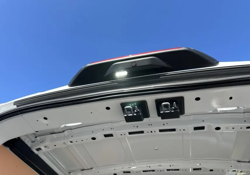 Vue en contre-plongée de l'intérieur de la porte arrière blanche du Ford Transit Fourgon avec caméra de recul et éclairage LED.