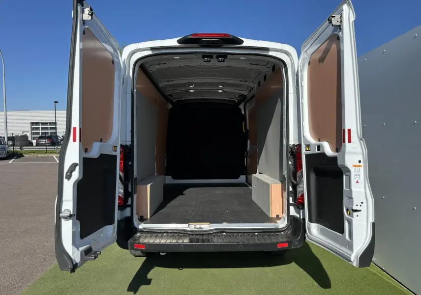 Vue arrière ouverte du Ford Transit Fourgon blanc 2020, montrant l'espace de chargement vide et les portes battantes ouvertes.