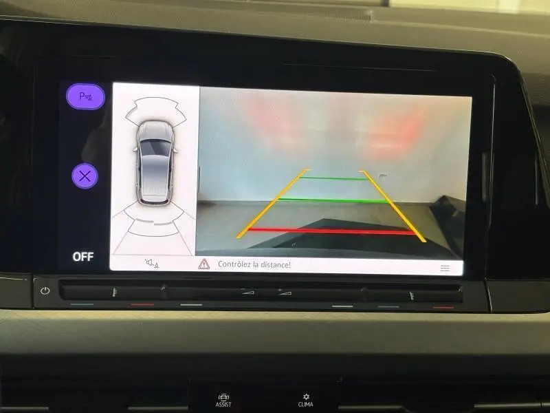 Écran tactile intérieur de la Volkswagen Golf 2024 montrant la caméra de recul avec lignes de guidage colorées.