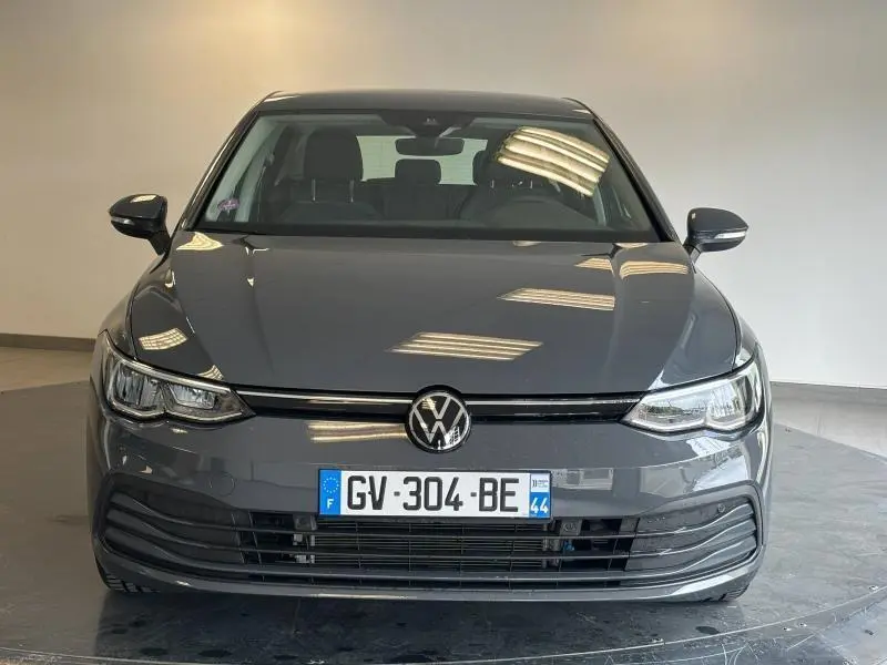 Volkswagen Golf gris dauphin métallisé vue de face, mettant en valeur ses phares LED et calandre épurée.