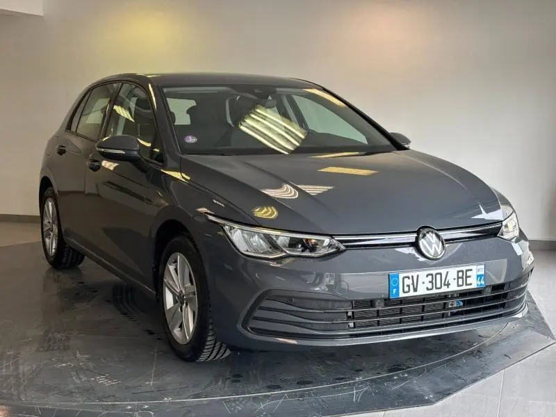 Volkswagen Golf gris dauphin métallisé vue 3/4 avant avec phares LED et calandre chromée.