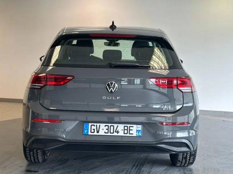 Vue arrière d'une Volkswagen Golf gris dauphin métallisée, avec feux LED et plaque d'immatriculation française visible.