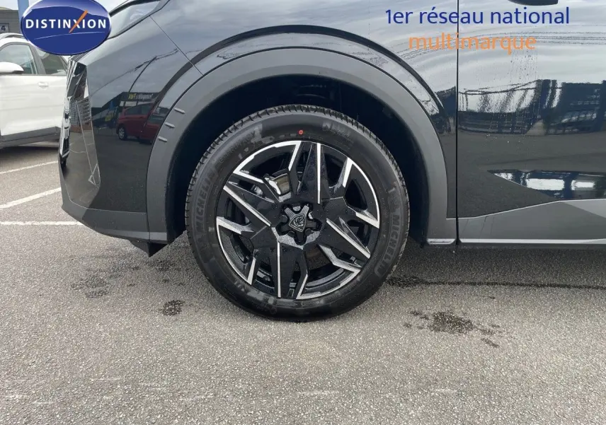 Gros plan sur la roue avant gauche d'un Peugeot 3008 noir perle métal avec jante alliage bicolore.