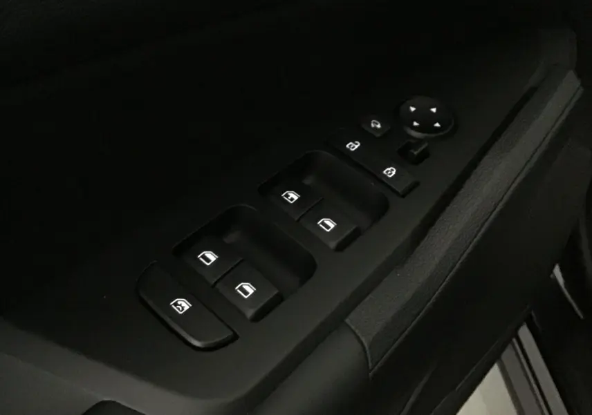 Gros plan sur les commandes des vitres électriques et rétroviseurs côté conducteur du Kia Sportage noir 2025.