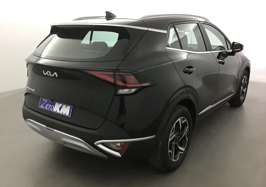 Vue 3/4 arrière droite du SUV KIA Sportage noir 2025 avec feux LED et jantes alliage distinctives.