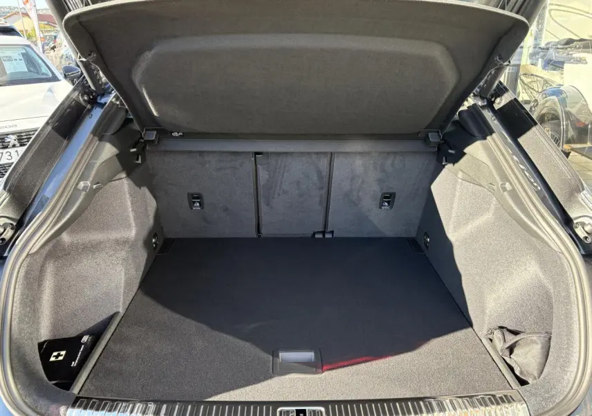 Coffre ouvert vu de l'arrière d'un Audi Q3 Sportback gris Daytona, espace de chargement propre et spacieux.