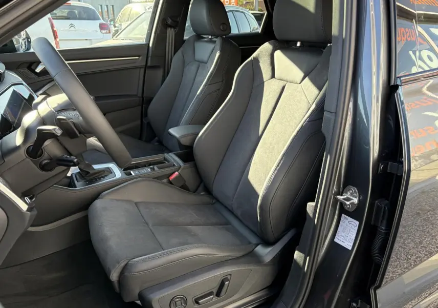 Vue intérieure côté conducteur de l'Audi Q3 Sportback gris Daytona avec sièges sport en tissu et alcantara noirs.