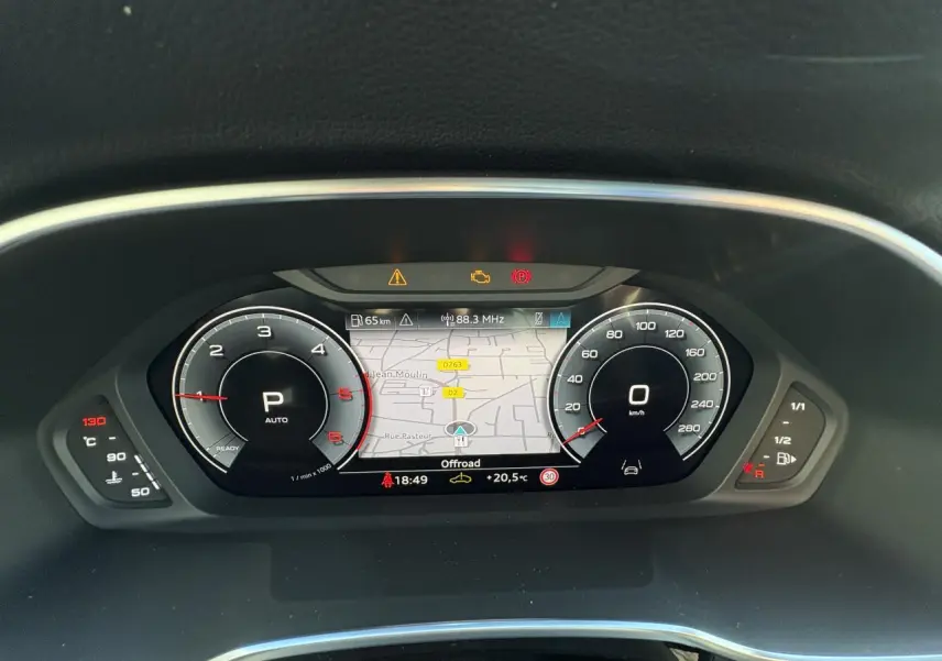 Combiné d'instruments numérique Audi virtual cockpit affichant la navigation et compteurs dans un Audi Q3 Sportback gris Daytona.